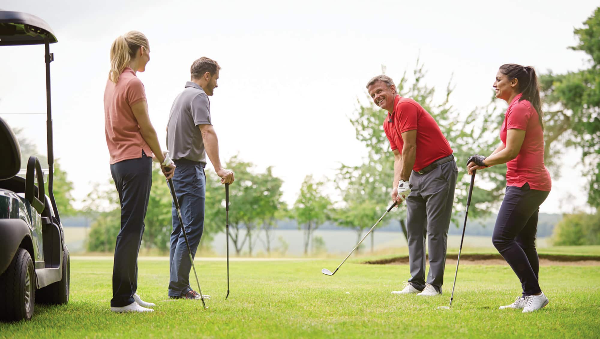 Two couples playing golf